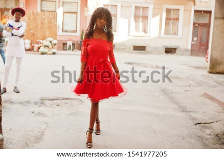 Stylish trendy afro france curly woman posed at autumn day in red dress. Black african female model.