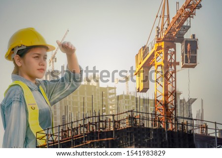 Asian engineer woman looking Successful with her job. Asian woman architect looking at the distance to lead to success with yellow helmet and jean shirt duplicate photo.Concept Engineer and civil work