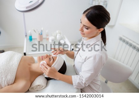 Relaxed young woman having skincare procedure at spa salon stock photo