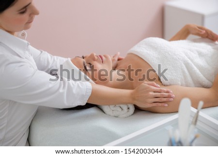 Smiling young woman enjoying massage stock photo
