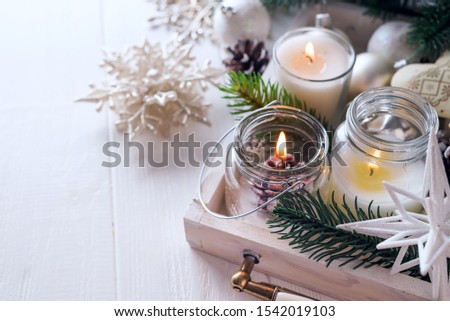 Rustic style with candles and christmas decorations on white wooden background, copy space