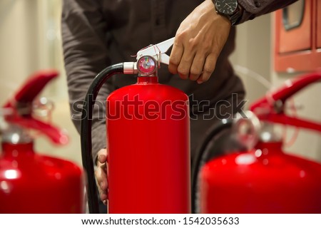 Fire extinguishers,Close-up  engineers hands are squeezing the Handle on the fire extinguisher.