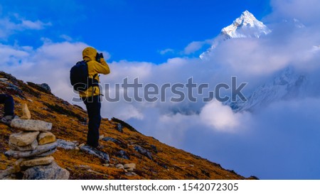 Male photographer taking pictures in Everest base camp trek, Nepal. Hiking to EBC. Views to Ama Dablam