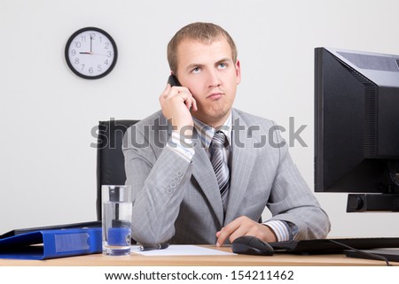 bored businessman talking on phone in his office