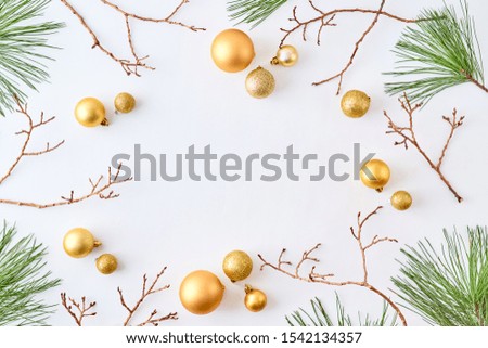 Flat lay frame with gold christmas balls and pine branches on a white background