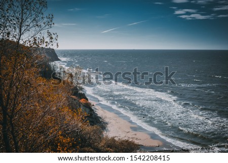 Sandy shore of the Baltic Sea during the stormy wheather. Stormy sea with waves in the autumn day.