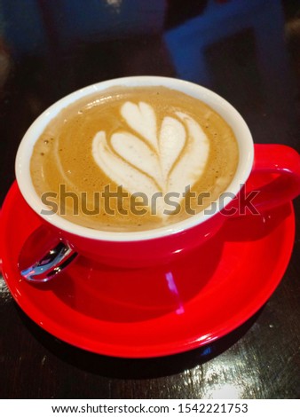 Close-up picture of hot capuccino in red cup and saucer