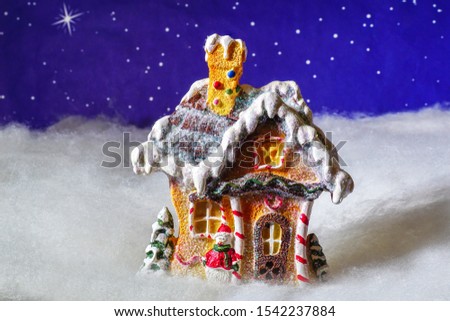 A gingerbread house on a snowy night.                         