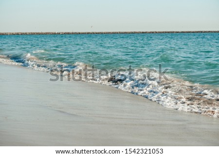 On the picture is Pacific Ocean Long Beach shore. Azure blue sea water disappears in the sand.
