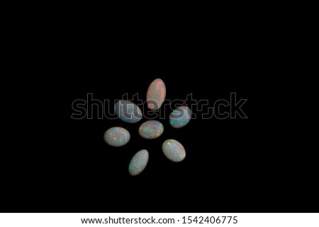 Australian precious opals ranging from light to dark body color and displaying the effect called play of color against a dark background
