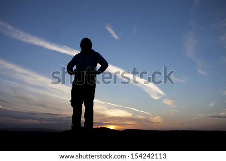 silhouette of proud man with hands on hips