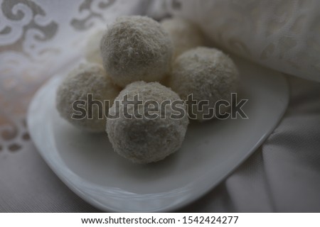 Delicious dessert white coconut candy, Raffaello homemade candy with filling of cream and nut on wooden background