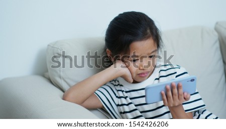 Little girl watch on cellphone at home