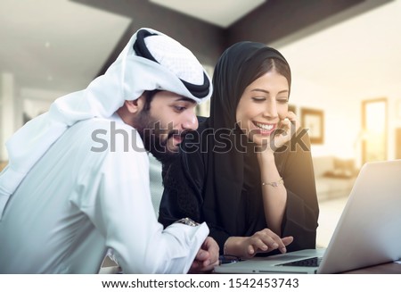 lovely Arabic Couple sitting using laptop looking for new house. Royalty-Free Stock Photo #1542453743