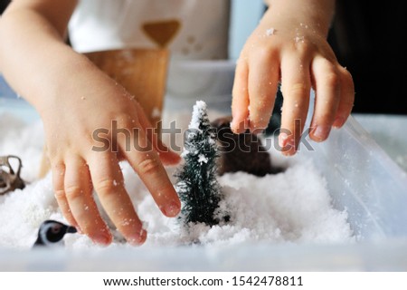 child plays with snow and toys