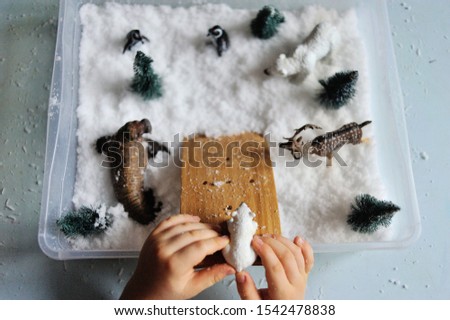 child plays with snow and toys
