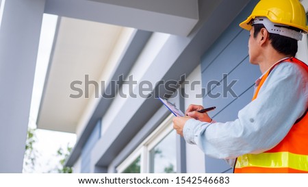 The inspector or engineer is checking the building structure and house roof specifications. After the renovate is complete Royalty-Free Stock Photo #1542546683