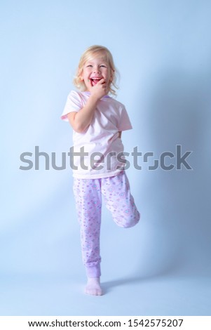 Cute happy baby is laughing fearless and freely with her new teeth, looking in to camera. Isolated on a light background.