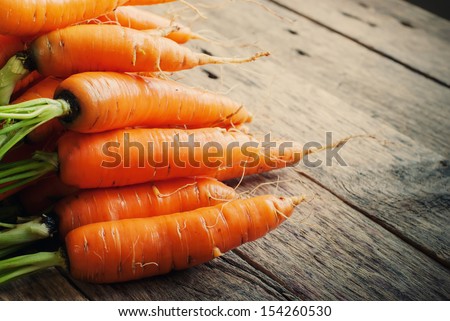Fresh Organic Carrots in a basket on wooden background, rustical, selective focus Royalty-Free Stock Photo #154260530