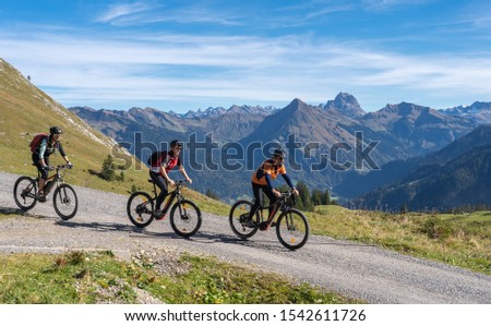 three happy senior adults, riding their mountain bikes in the autumnal atmosphere of the Bregenz Wald mountains near Mellau, Vorarlberg, Austria