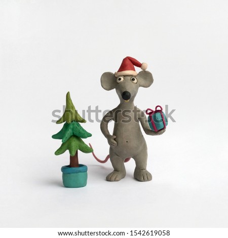 Plasticine illustration with a Christmas tree and a mouse with a gift in the paw