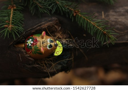 the branch of fir tree and a mouse with cheese in the hollow