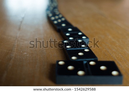 Playing dominoes on a wooden table. Dominoes game concept.