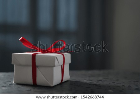 White gift box red ribbon on terrazzo countertop with copy space
