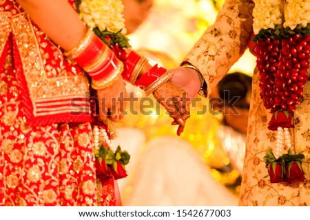 Closeup of indian wedding couple holding hands and promise to be together for lifetime. Royalty-Free Stock Photo #1542677003
