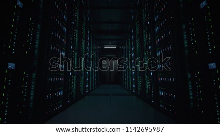 Camera slowly moving along the narrow corridor in data center with server equipment on both sides, the lights gradually turning off until total darkness. Photorealistic 3D render animation.