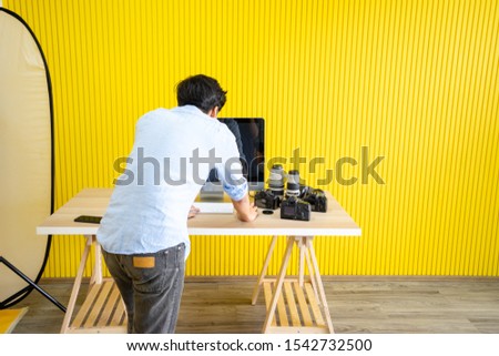 Portrait of a photographer covering man face with the camera indoor studio, photography looking and correct shooting image, photography concept