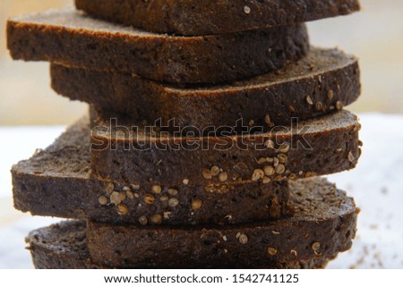 A loaf of black bread cut into pieces and sprinkled with coriander close-up. Concept - healthy natural food, diet