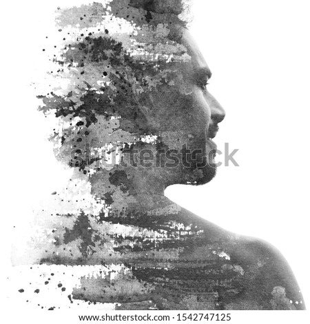 Paintography. Double exposure portrait of a man with strong features combined with handmade ink painting of brushstrokes which dissolve across his back and face