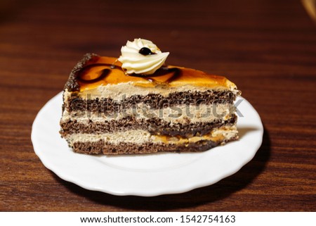 Slice of chocolate cake with multiple layers of stout-infused chocolate biscuit and stout milk cream with maple syrup.