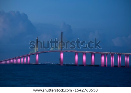 The iconic Sunshine Skyway Bridge spanning the wide mouth of beautiful Tampa Bay in central Florida lit up in pink LED lights to commemorate Breast Cancer Awareness Month.