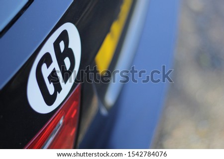 Country designation/origin sticker/badge on the back of a black estate vehicle ready for traveling to Europe. Royalty-Free Stock Photo #1542784076