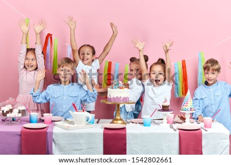 careless happy childhood. children laughing, shouting with pleasure, isolated dpink background, studio shot