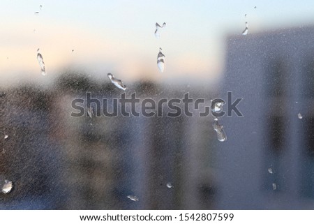 Balcony window with frozen water drops on it. Photographed during a cold winter day in Finland. Beautiful, detailed closeup image of the water turned into ice. Blue, white and black tones. Closeup.