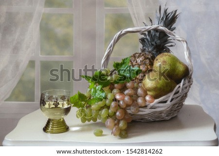 Still life with white wine glass and fruit basket