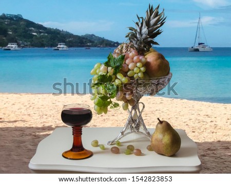 Still life with wine glass and fruit vase on the sea beach