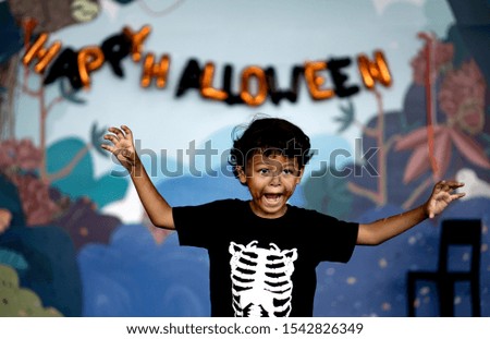 Pictures of cute and funny Asian boy posing to look scary for Happy Halloween!