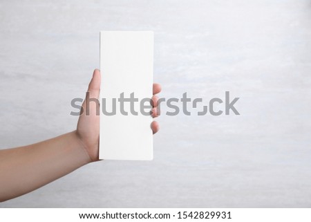 Man holding blank palm cards on light background. Mock up for design