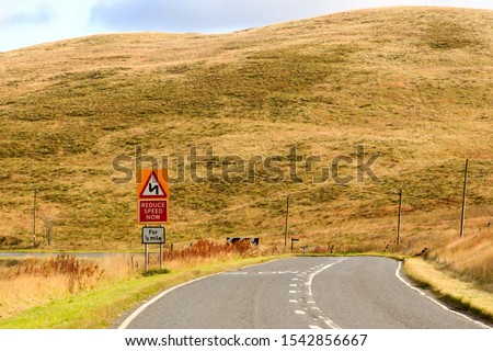 Road sign advising Reduce Speed Now for half mile