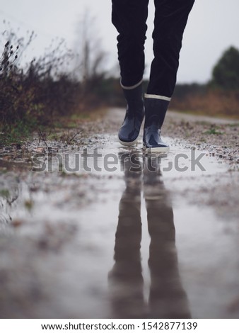 walking in rubber boots through puddle
