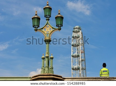 police man London Eye, Westminster Bridge stock, photo, photograph, image, picture from low angle on bank of river Thames