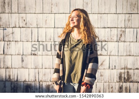 Cute teen girl 17 with glasses, smiling, warm sunlight portrait