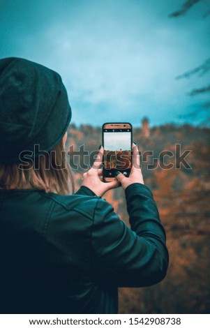 Autumn morning, girl taking picture with smartphone. Latvia