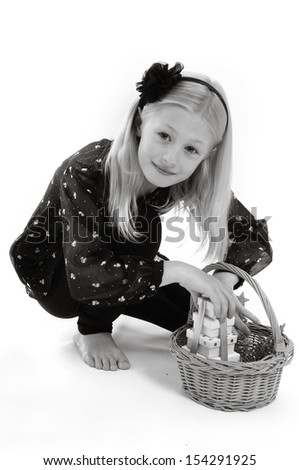 pretty blonde girl with basket, carrying Christmas presents, isolated on white in monochrome