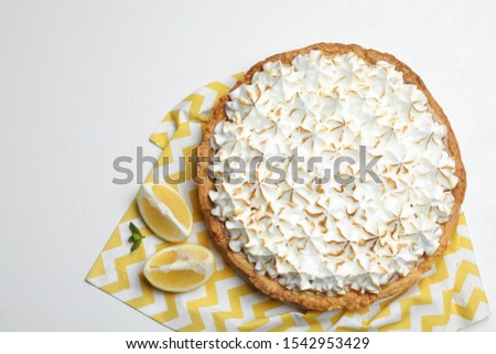Composition with delicious lemon meringue pie on white table, top view