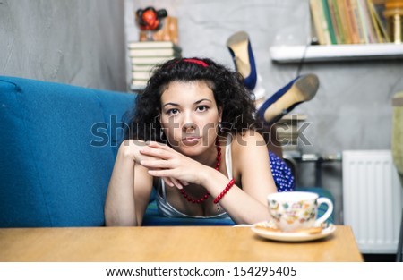 Young woman lay on soft sofa and looking